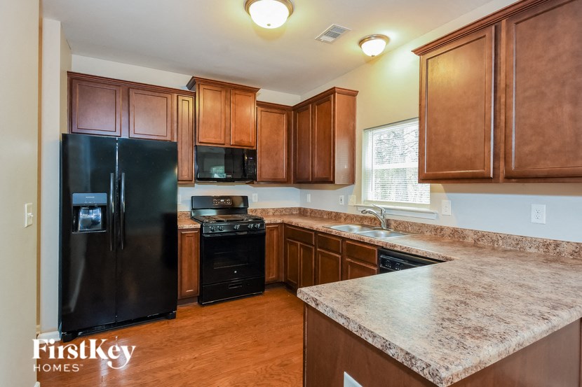 a kitchen with wooden cabinets and a black refrigerator