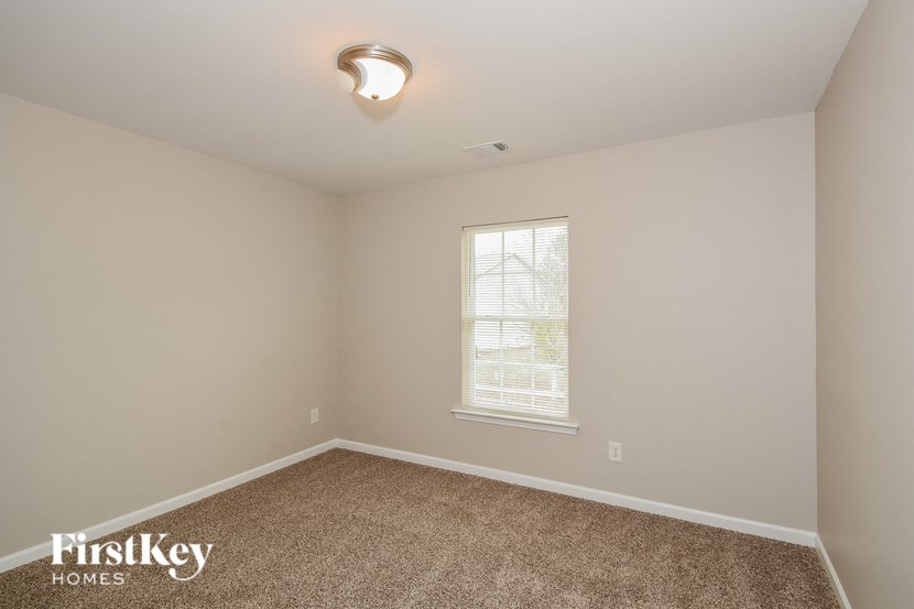 a bedroom with a carpeted floor and a window
