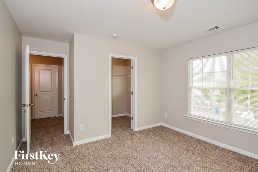 a bedroom with a door to a closet and a window
