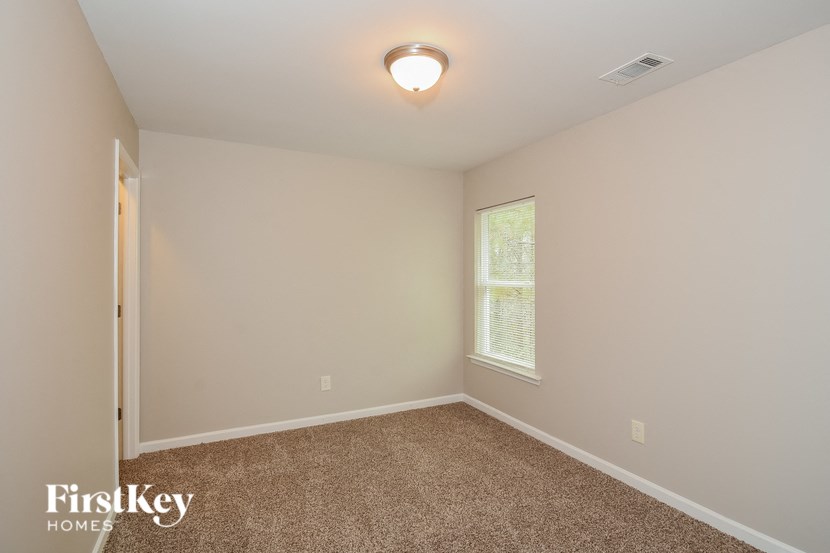 a bedroom with a carpeted floor and a window