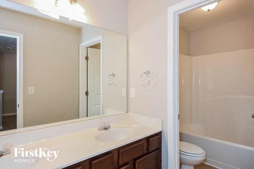 a bathroom with a large mirror and a sink and a toilet
