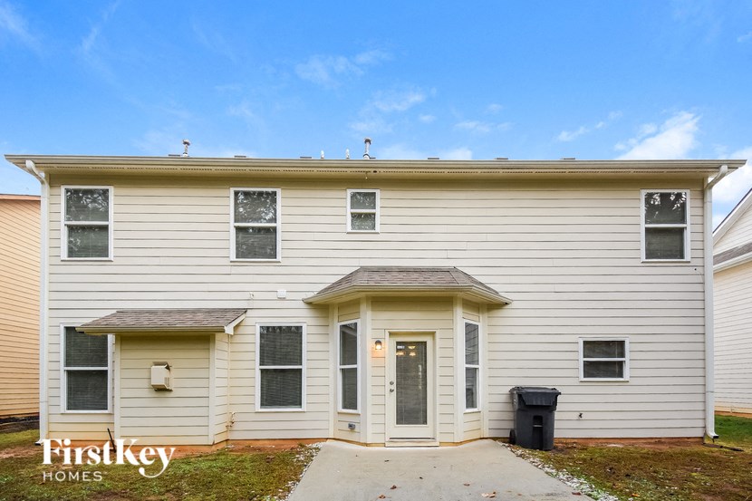 the front of a white house with a driveway