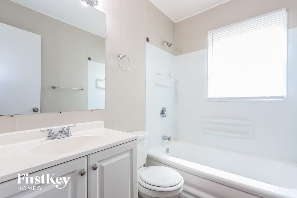 A white bathroom with a toilet, sink, and bathtub.