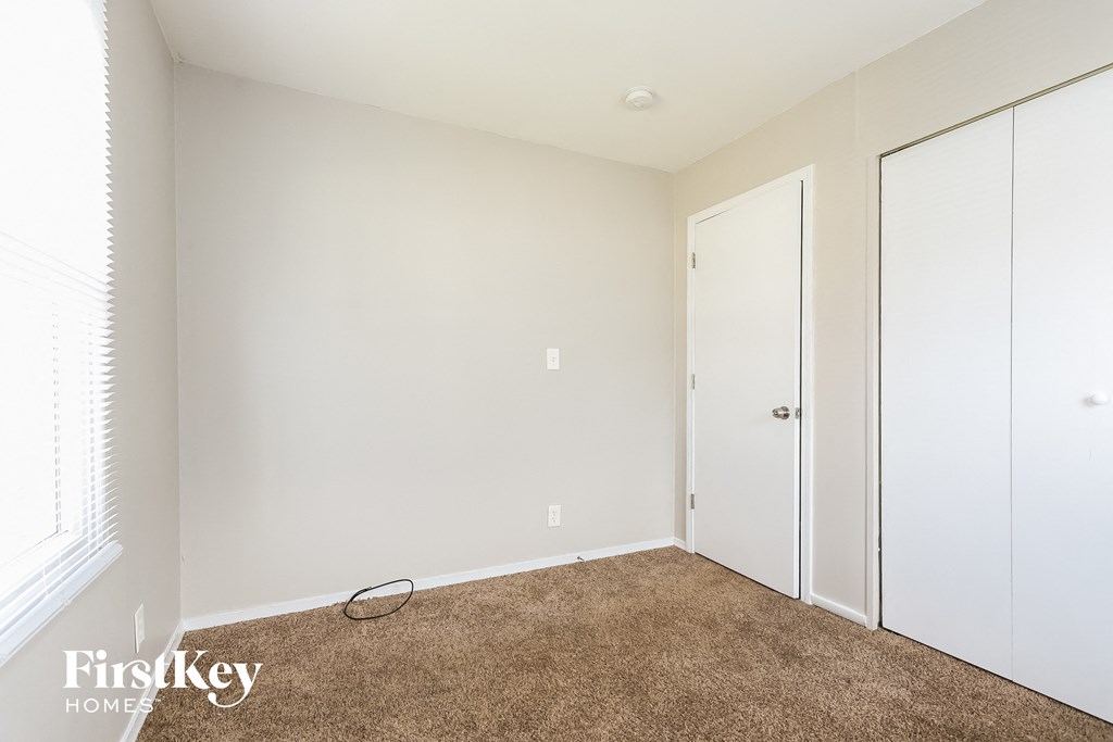 A room with a brown carpet and a white door.
