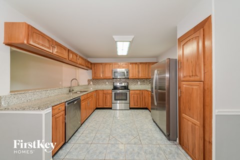 A kitchen with wooden cabinets and a refrigerator.