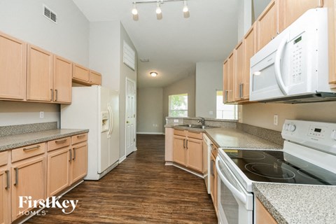A kitchen with wooden cabinets and a white fridge.