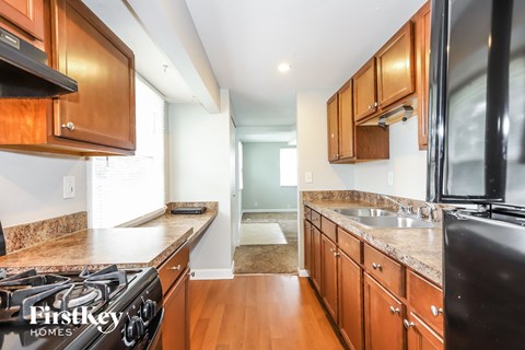 A kitchen with wooden cabinets and a black stove top oven.