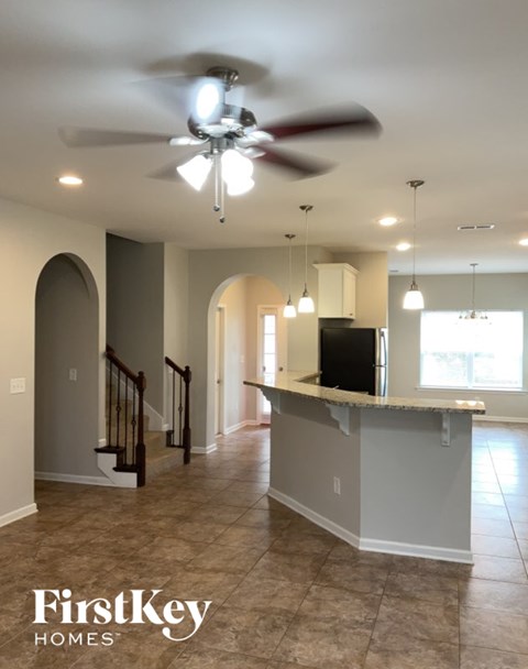 A kitchen with a fan and a counter top.