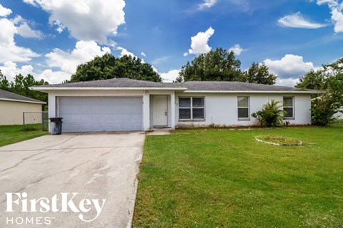 A white house with a garage door is for sale by FirstKey Homes.