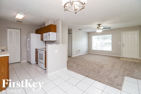 A kitchen with a refrigerator, microwave, and oven.