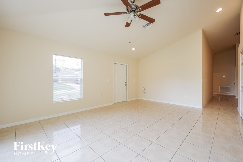 A spacious room with a ceiling fan and tile flooring.