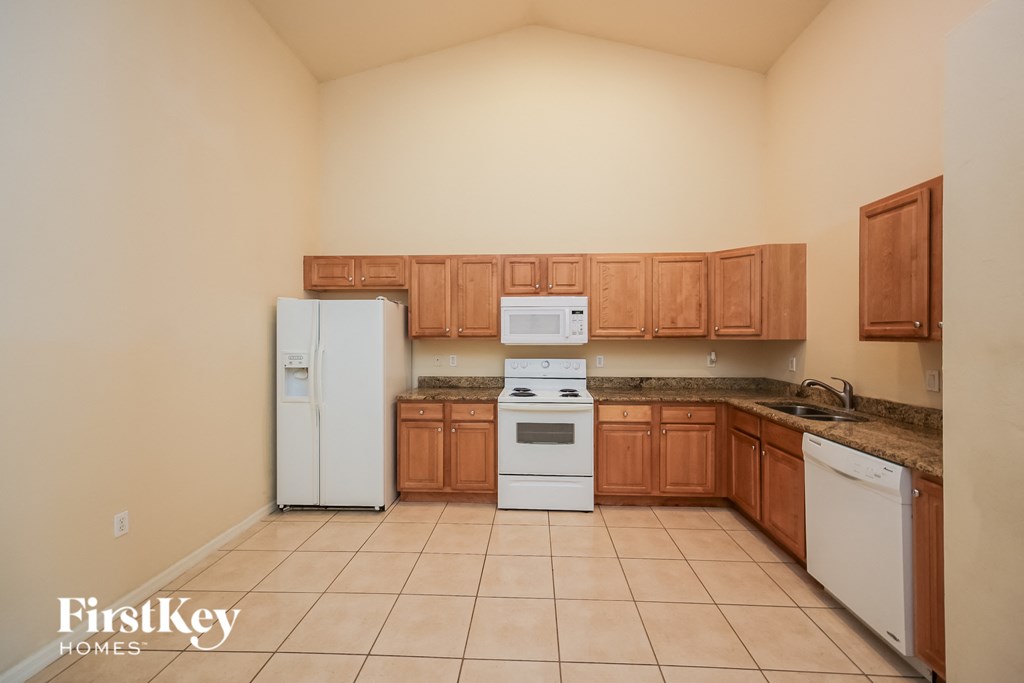 A kitchen with wooden cabinets and white appliances.