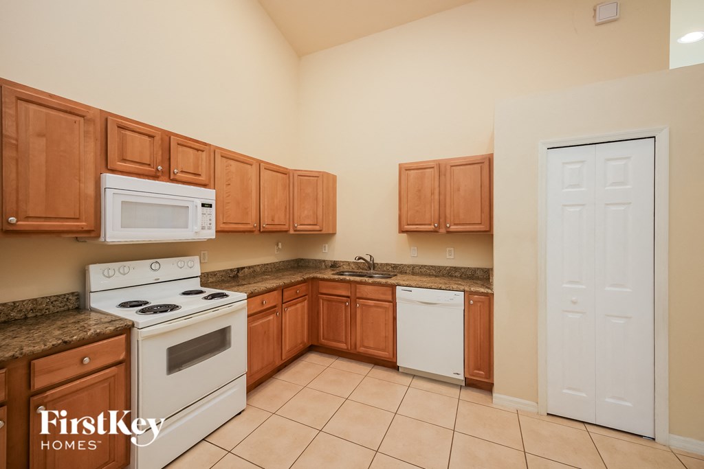 A kitchen with wooden cabinets and a white stove.