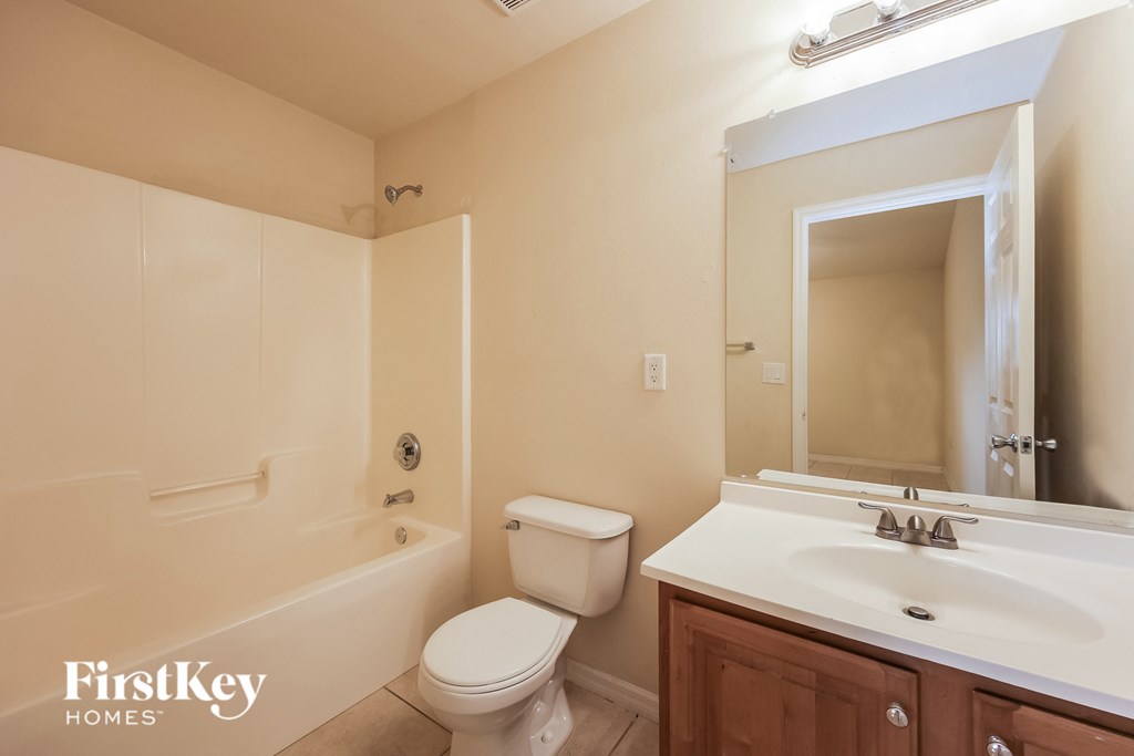 A bathroom with a toilet, sink, and bathtub.