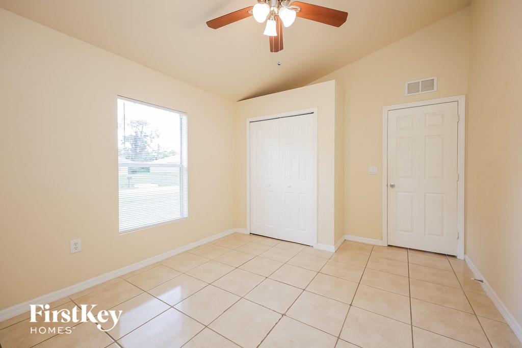 A room with a ceiling fan and two doors.