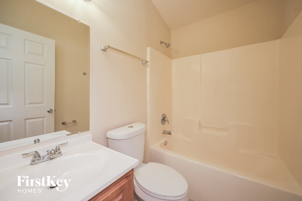 A white toilet sits next to a sink in a bathroom.