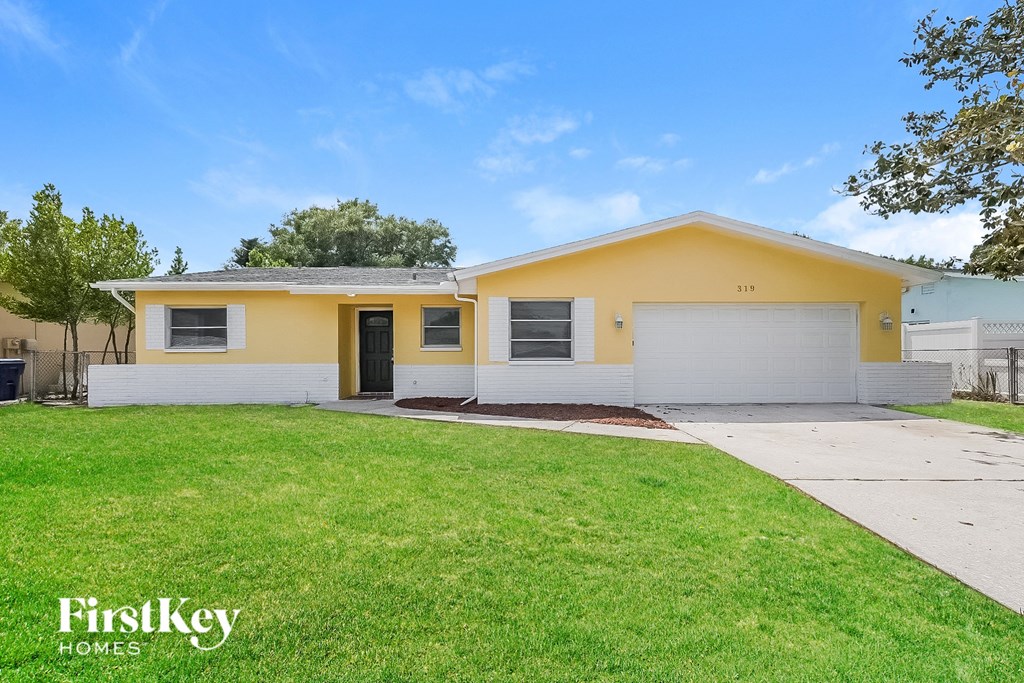 A yellow house with a white garage door and a black door.