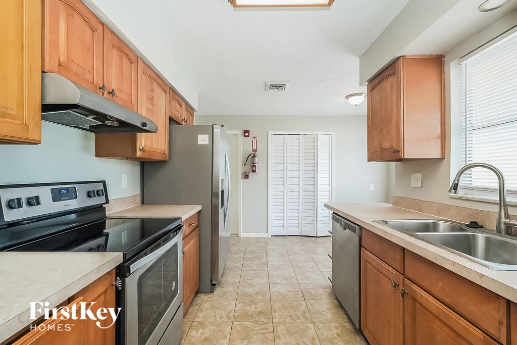 A kitchen with wooden cabinets and a stove top oven.