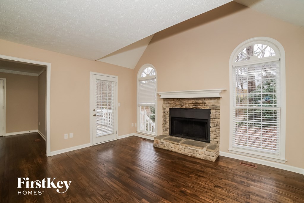 the living room of a house with a fireplace and wooden floors