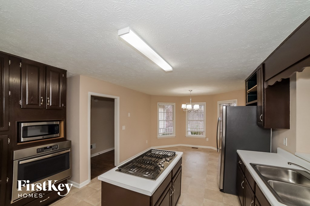 a kitchen with a stove and a refrigerator and a sink