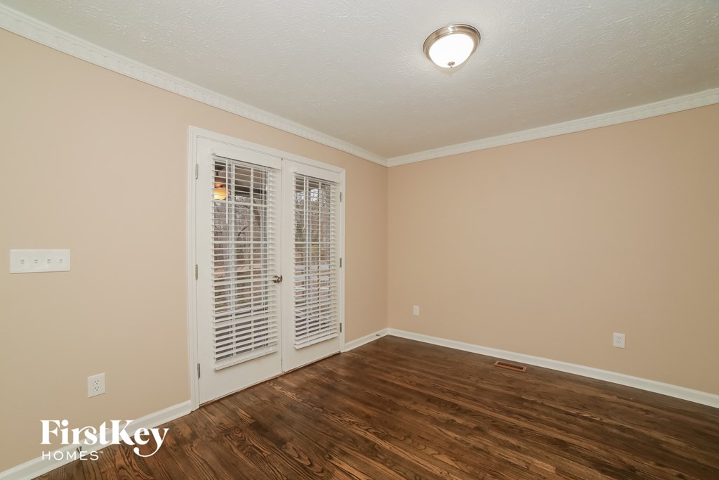 the living room of a house with a hard wood floor and doors