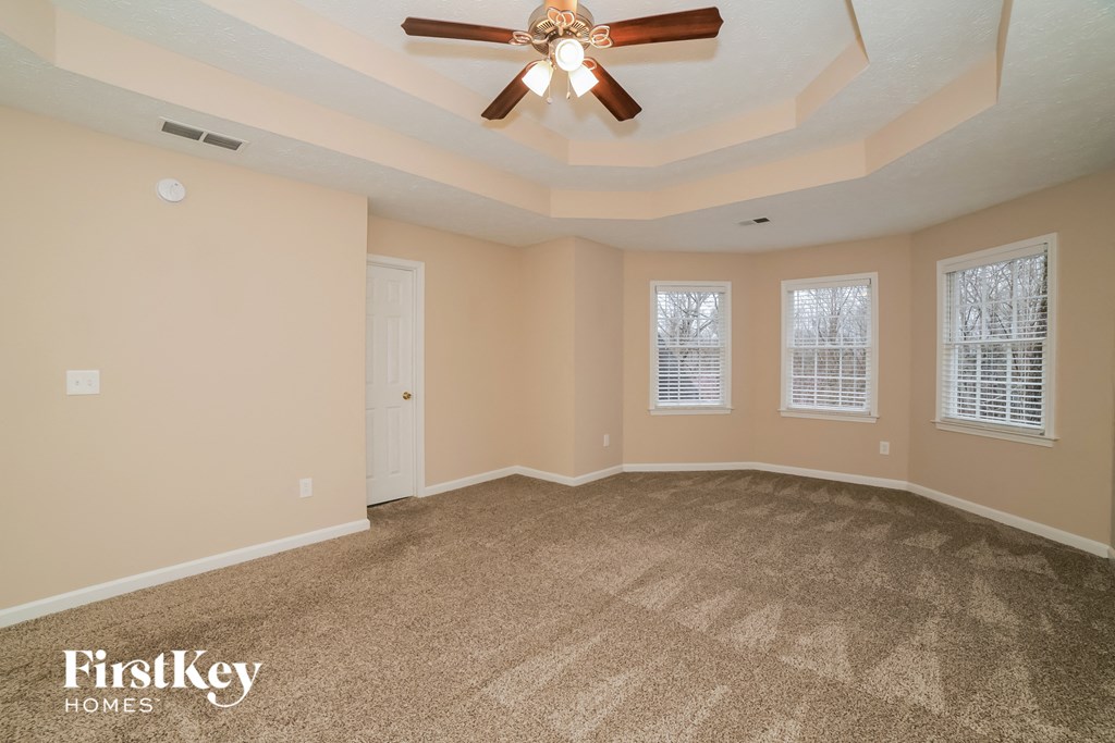 the living room of an empty house with a ceiling fan