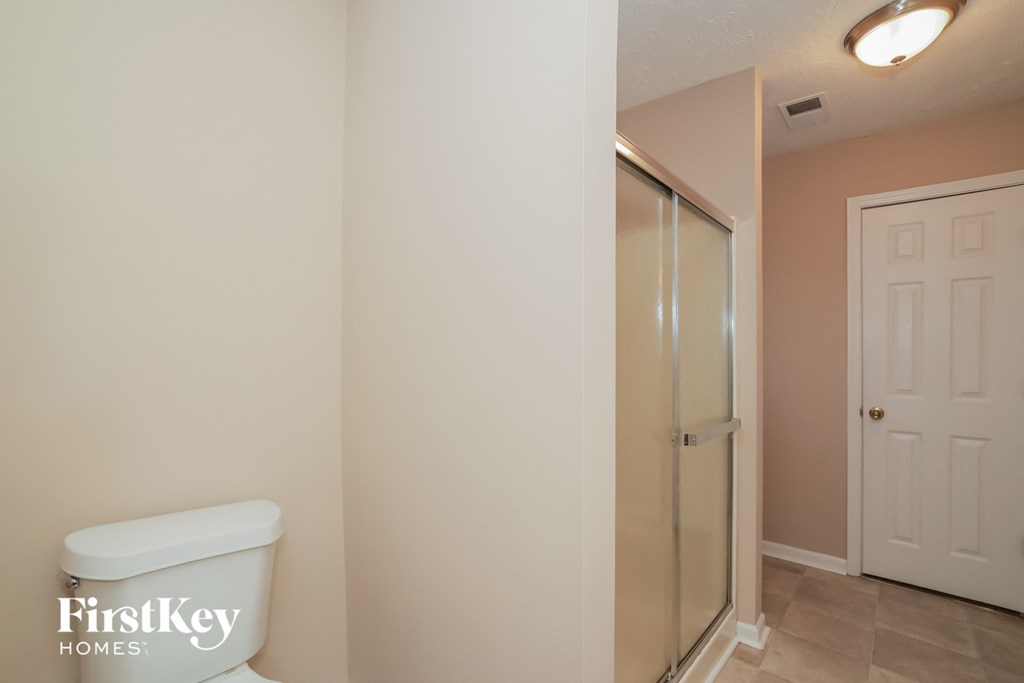 a bathroom with a toilet and a shower in it