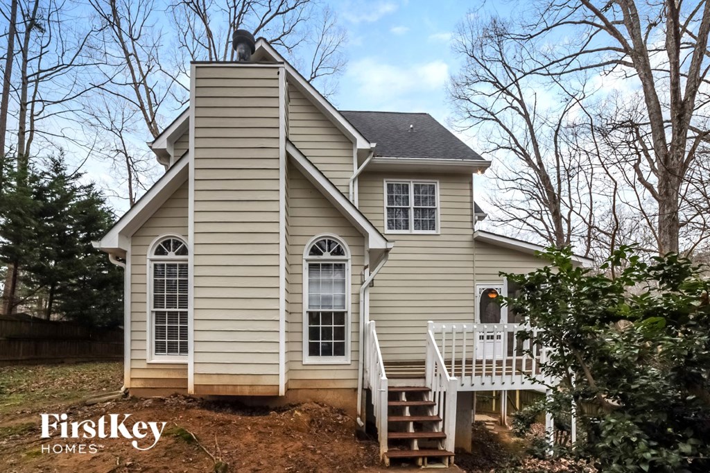 a small house with a deck and a white staircase
