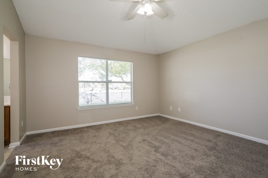 a bedroom with a carpeted floor and a window