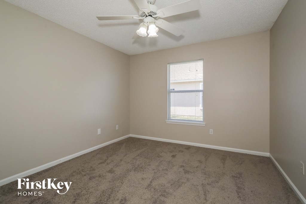 a bedroom with a ceiling fan and a window
