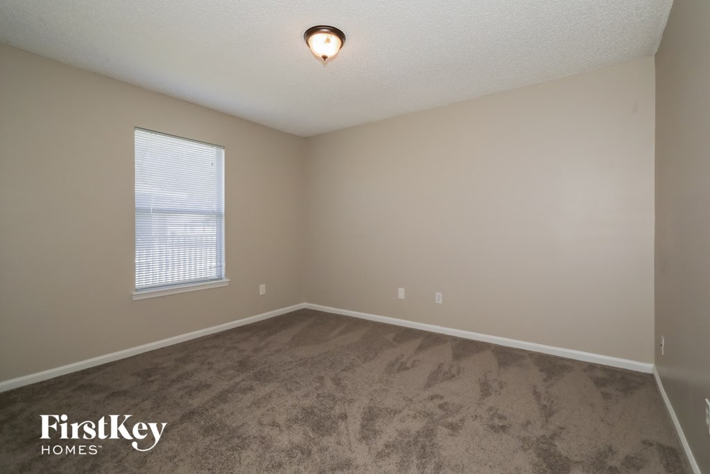 the upstairs bedroom with carpeted flooring and a window