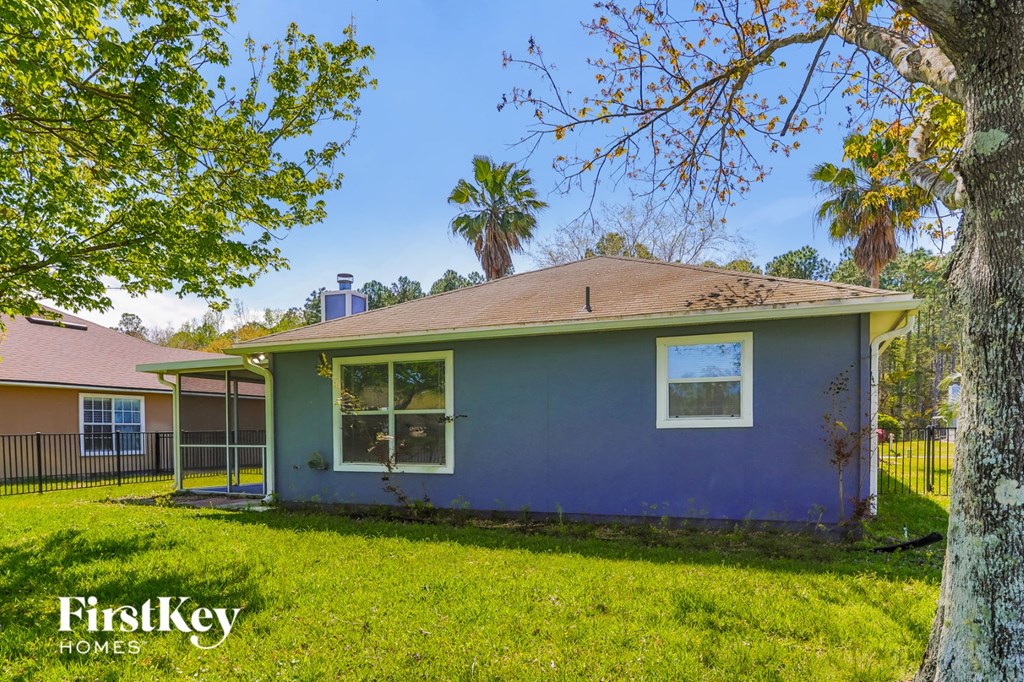 a blue house with a yard and a palm tree
