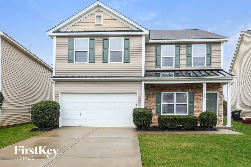 a tan brick house with a white garage door