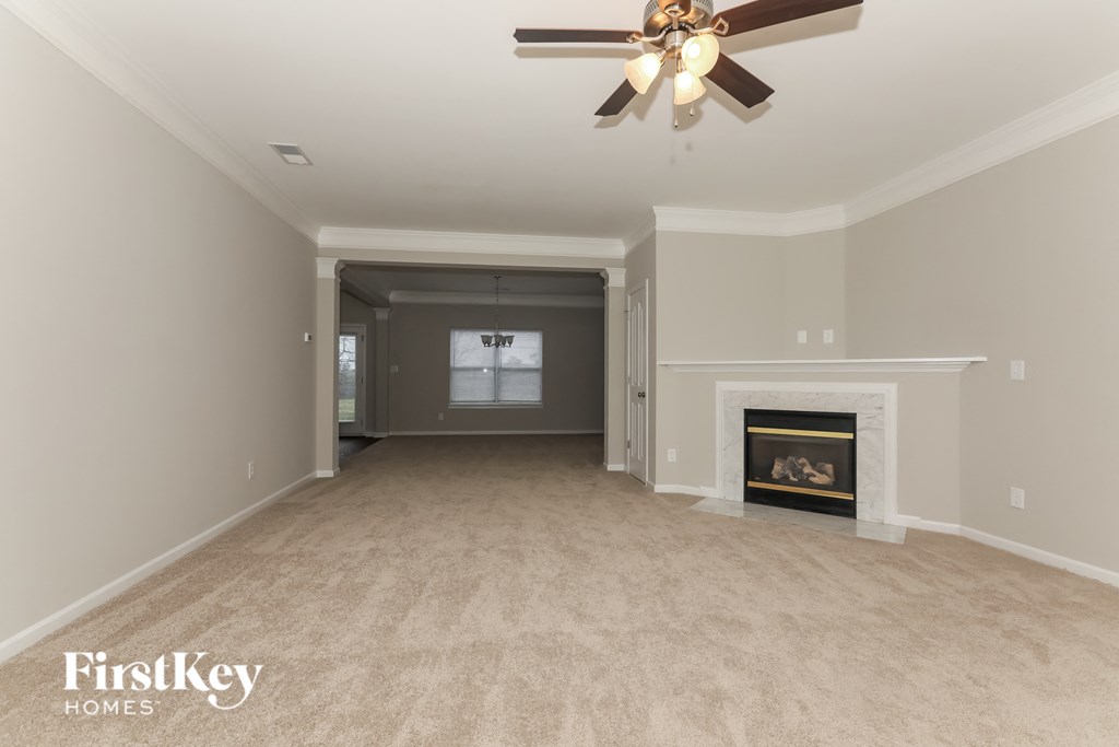 a living room with a fireplace and a ceiling fan