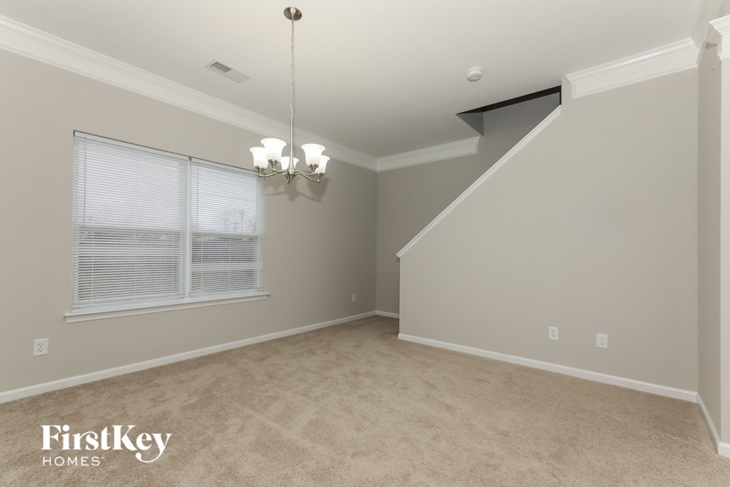 the spacious dining room with vaulted ceilings and a large window
