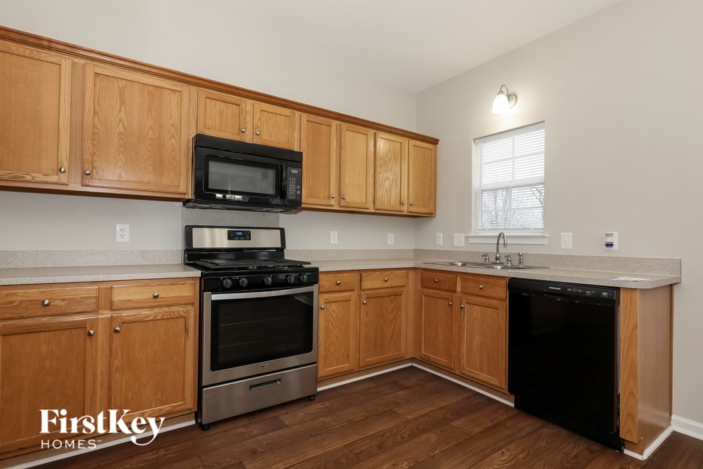 a kitchen with wooden cabinets and black appliances and stainless steel appliances