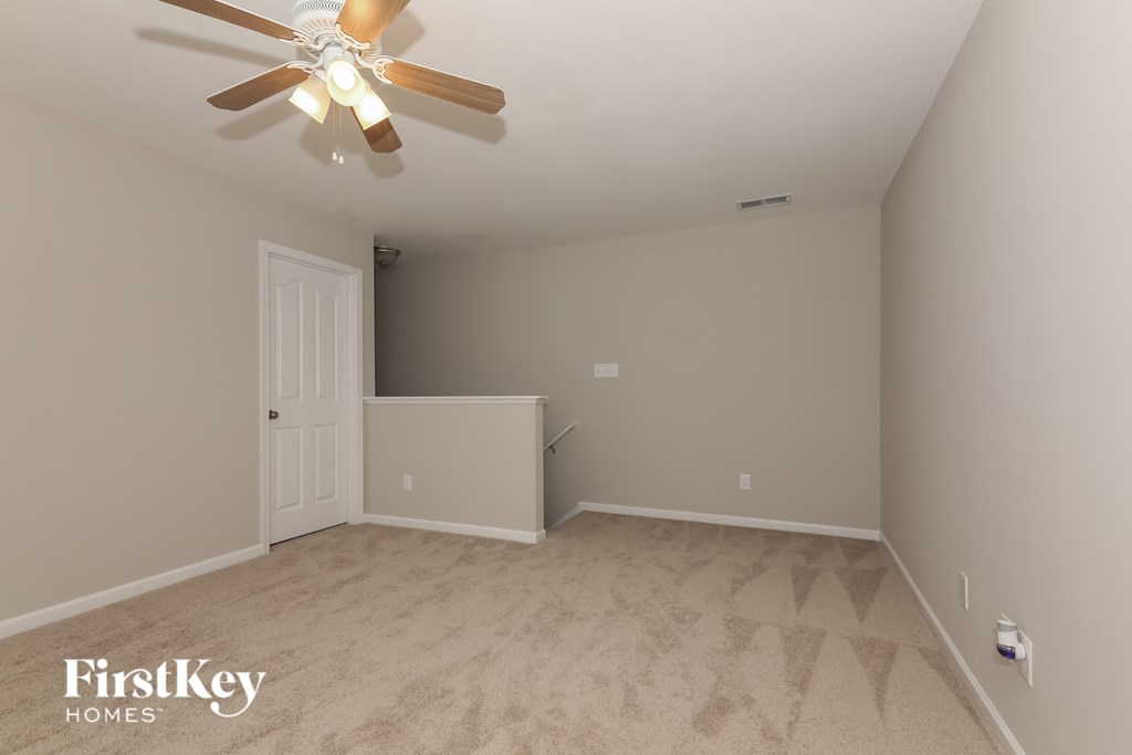 a empty bedroom with a ceiling fan and a closet