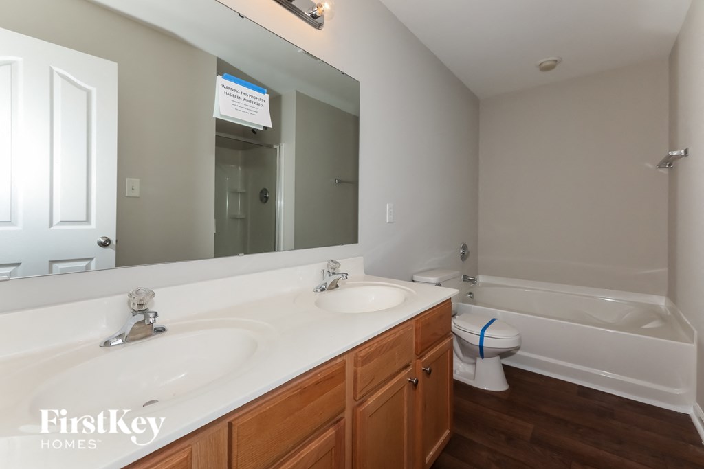 a bathroom with two sinks and a toilet and a mirror