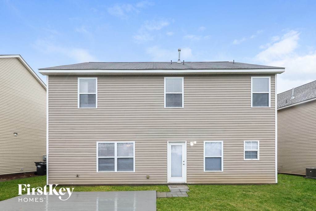 side view of a house with brown siding and a green lawn