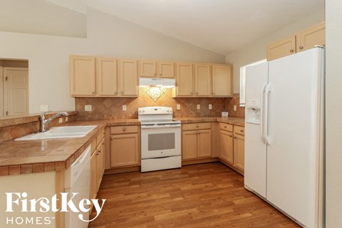 A kitchen with wooden cabinets and a white fridge.