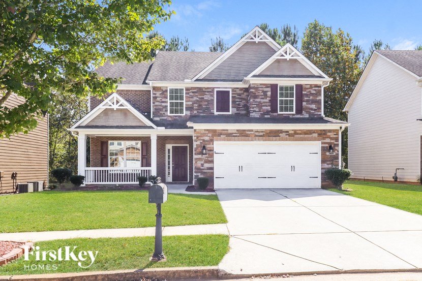 A house with a garage and a mailbox in front.