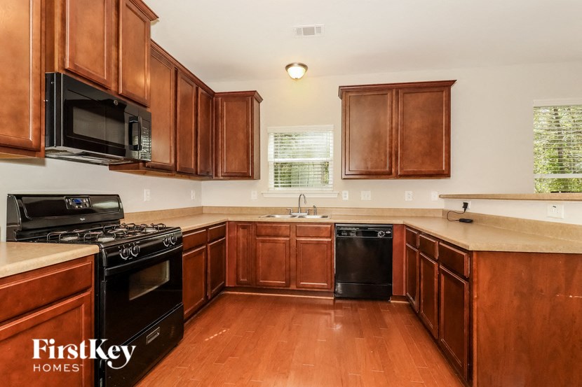 A kitchen with wooden cabinets and a black stove top oven.