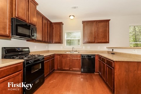 A kitchen with wooden cabinets and a black stove top oven.