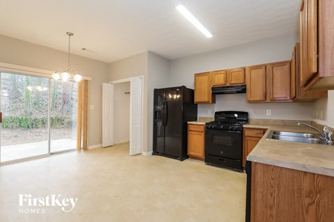 A kitchen with wooden cabinets and black appliances.
