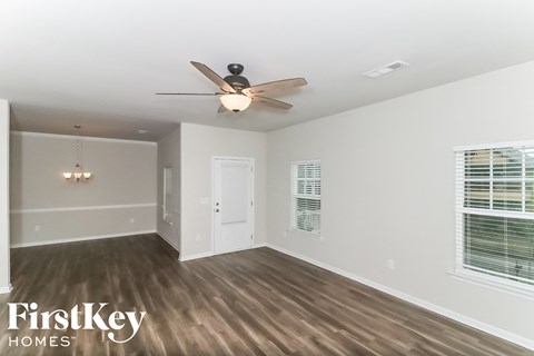 a living room with a ceiling fan and a window