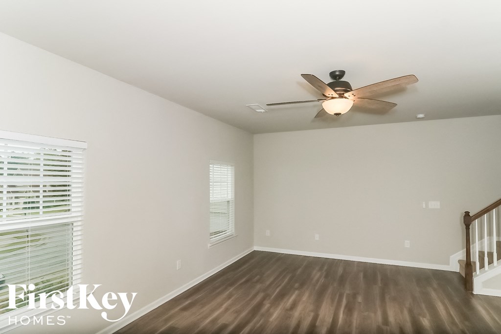 a living room with wood floors and a ceiling fan