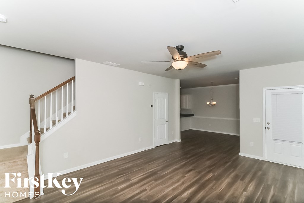 a living room with white walls and a ceiling fan