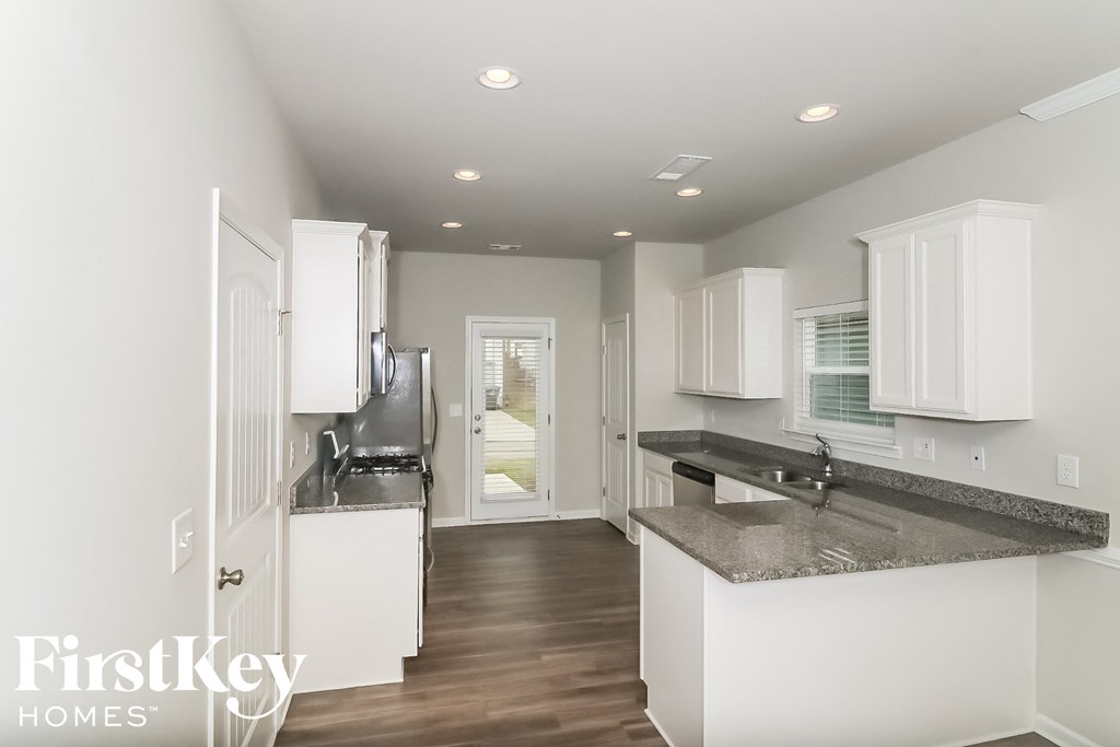 a white kitchen with marble counter tops and white cabinets