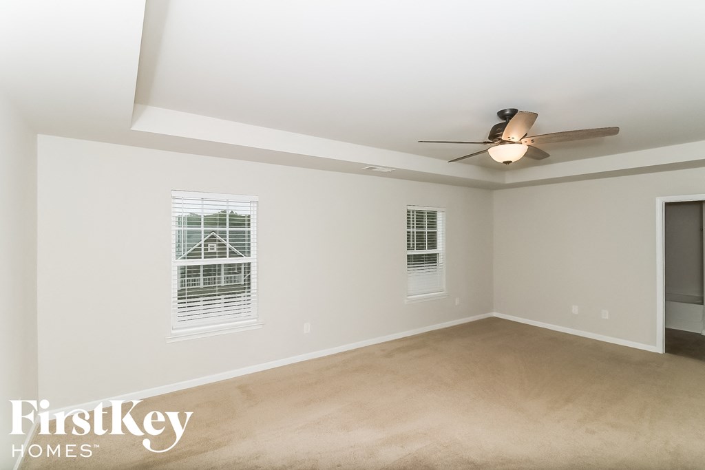 a living room with white walls and a ceiling fan