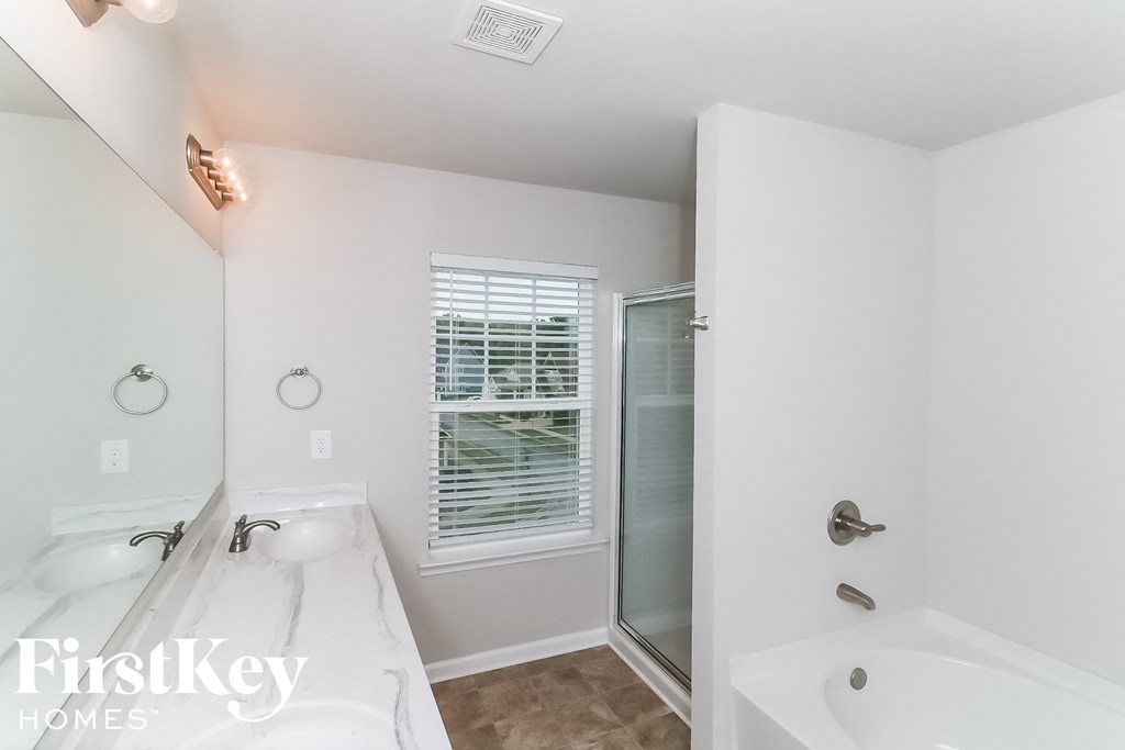 a bathroom with a tub and a sink and a shower
